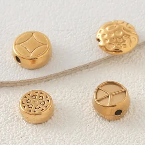 Gros plan de perles en acier inoxydable doré avec motifs en relief pour bijoux DIY.