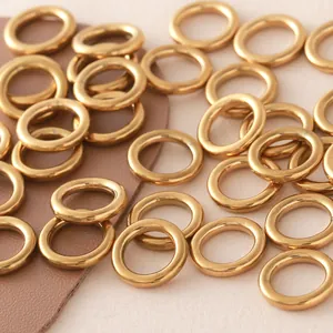 Close-up of golden stainless steel seamless O-rings on a textured background