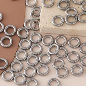 Macro view of silver stainless steel closed rings on textured stone and leather