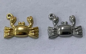 Detailaufnahme von gold- und silberfarbenen Edelstahl-Krebsanhängern für DIY-Schmuck
