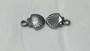 Detailed macro view of two stainless steel ocean shell charms for DIY jewelry making projects.