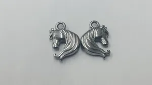 Detailed view of two stainless steel horse head charms for DIY personalized jewelry making.