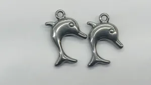 Detailansicht von zwei polierten silbernen Delfin-Anhängern für DIY-Handwerksschmuck