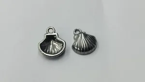 Detail view of two small silver stainless steel shell charms for DIY jewelry making.