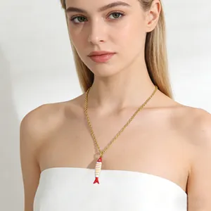 Minimalist stainless steel necklace with a colorful striped fish pendant on a model