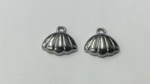 Detailed macro shot of stainless steel shell charms for DIY jewelry making.