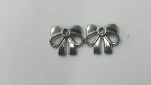 Detailopname van twee zilveren roestvrijstalen strikhangers voor DIY-sieraden maken.