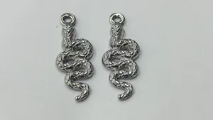 Detailed view of two silver stainless steel snake-shaped charms for jewelry making.