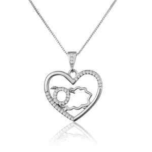 Detailed close-up view of a silver heart pendant with zodiac sheep and zircon stones