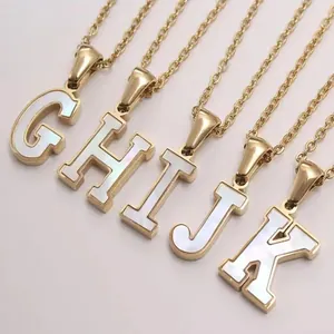 Close-up of golden alphabet necklaces G to K with pearlescent white shell inlay