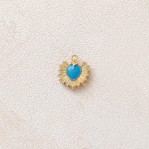 Macro dettagliata di un ciondolo a cuore dorato con smalto blu e motivo a raggiera.