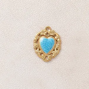 Dettaglio di un ciondolo a cuore vintage placcato oro con smalto floreale azzurro