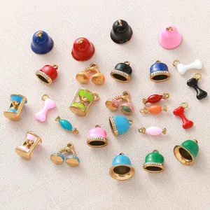 Close-up of colorful gold-plated stainless steel charms in bell, hourglass, and candy shapes