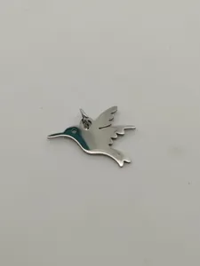 Close-up detail of a polished stainless steel hummingbird pendant charm for jewelry