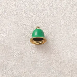 Close-up detail of a green enamel and gold-plated bell charm for DIY jewelry crafting