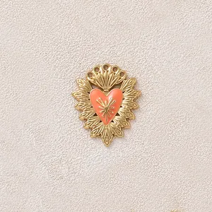 Vista dettagliata di un ciondolo a cuore dorato vintage con intarsio in smalto arancione
