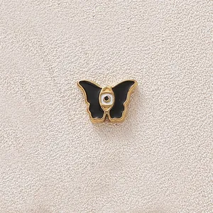 Gold-plated stainless steel butterfly pendant with black enamel and central evil eye design
