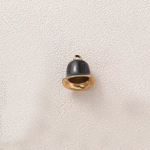 Close-up of a black and gold stainless steel bell pendant for DIY jewelry