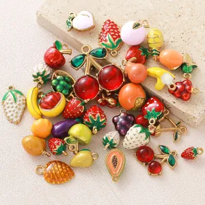 Dettaglio ravvicinato di vari ciondoli a forma di frutta 3D smaltati per gioielli fai-da-te.