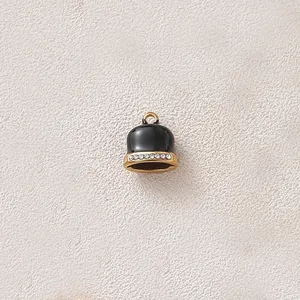 Detail view of a black enamel bell pendant with rhinestone band for DIY jewelry.