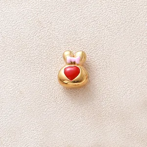Gros plan d'une perle de lapin dorée avec un cœur rouge et un nœud rose détaillé