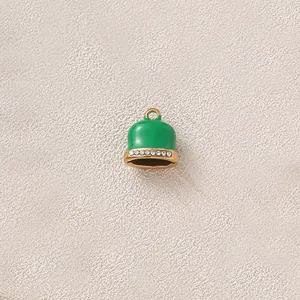 Close-up of green enamel bell pendant with crystal accents for DIY jewelry making