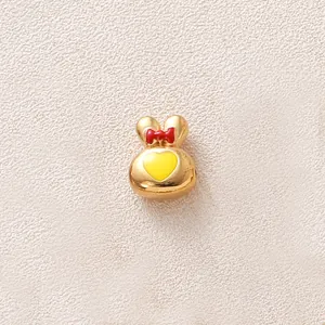 Vue détaillée d'une adorable perle lapin dorée avec nœud rouge pour bijoux artisanaux