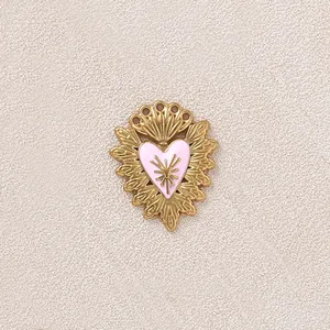 Primo piano di un ciondolo a cuore in acciaio inossidabile dorato con smalto rosa