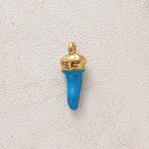 Detaillierte Nahaufnahme eines vergoldeten Chili-Anhängers mit blauem Emaille-Finish