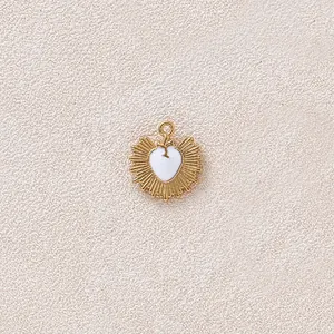 Primo piano di un ciondolo a cuore sacro dorato vintage con dettagli in smalto bianco