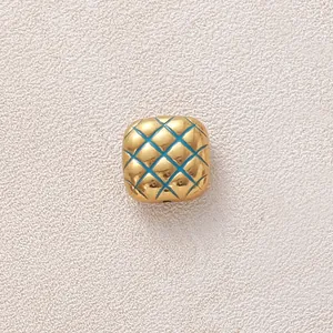Detailansicht einer vergoldeten Edelstahlperle mit blauem Emaille-Steppmuster für DIY.