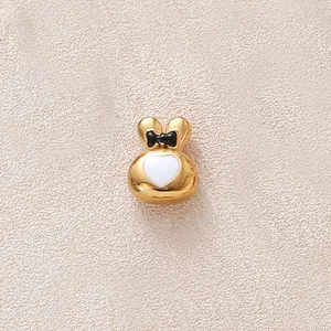 Vue macro de la perle lapin plaquée or avec cœur blanc et nœud noir détaillés