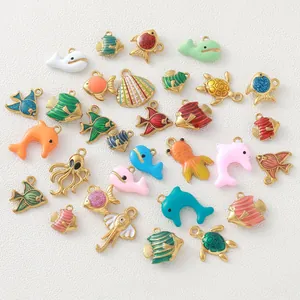 Detailed view of colorful ocean-themed gold-plated enamel charms for DIY jewelry