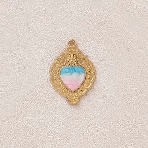 Dettaglio del ciondolo a cuore dorato vintage con smalto blu e rosa per gioielli fai-da-te.