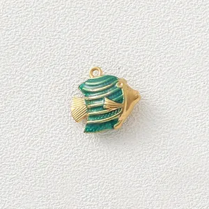Detail view of a golden tropical fish charm with green enamel stripes for DIY jewelry.