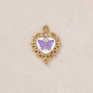 Vista macro dettagliata di un ciondolo a cuore vintage dorato con farfalla viola.