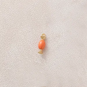 Close-up detail of an orange candy-shaped oil-dripping jewelry pendant component for DIY