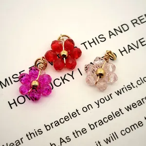 Close-up of colorful crystal flower charms with elegant gold-plated wire wrapping