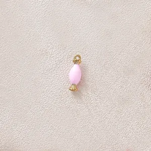 Detail view of a pink candy-shaped dripping oil pendant with gold-plated ring.