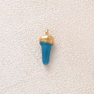 Nahaufnahme eines blau emaillierten, vergoldeten Chilipfeffer-Anhängers für DIY-Schmuck.