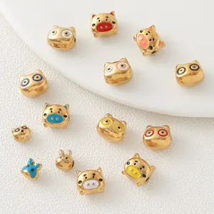 Macro view of gold-plated animal pig and rabbit beads with colorful enamel details