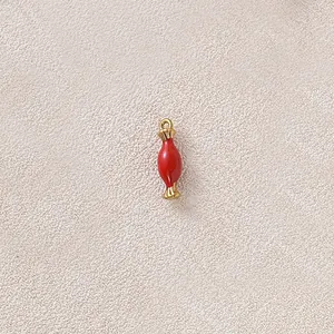 Macro view of a red enamel candy hourglass charm accessory for DIY jewelry making projects.