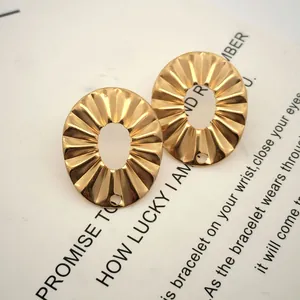 Nahaufnahme goldener Ohrring-Komponenten aus Edelstahl mit Plisseemuster und Loch