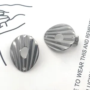 Dettaglio macro di perno per orecchino ovale in acciaio inox testurizzato con foro