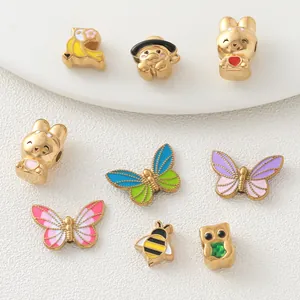 Detailed view of 18K gold-plated stainless steel butterfly and bee enamel charms
