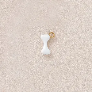 Detailed view of white bone-shaped charm with gold-plated ring for DIY jewelry making projects