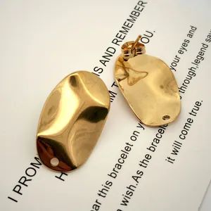 Detalle de fornituras para pendientes de acero inoxidable dorado con textura plegada