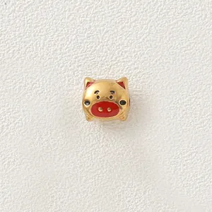 Detailed view of a gold-plated stainless steel cartoon pig bead with red enamel