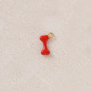 Macro view of a red bone shaped enamel charm with a gold-plated ring for DIY jewelry