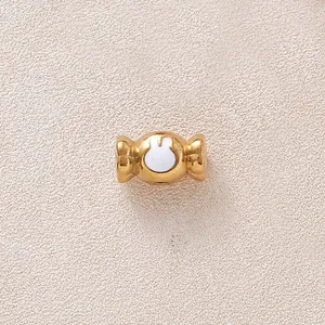 Vue macro d'une perle bonbon dorée avec un motif lapin en huile égouttée blanche.